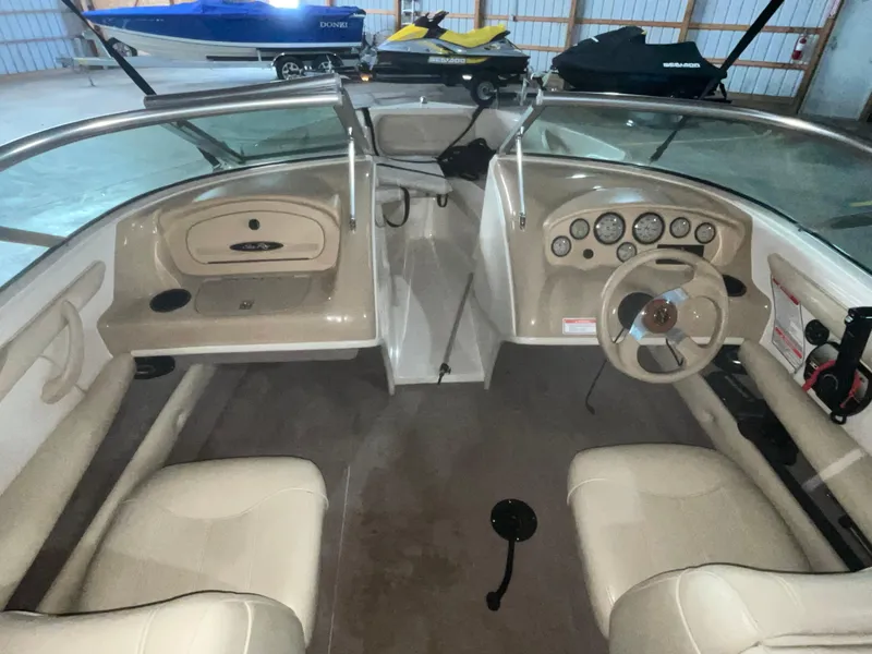 Slide: The Image of 2000 Sea Ray 185 Bow Rider interior with steering wheel and dashboard in a storage area. - 10