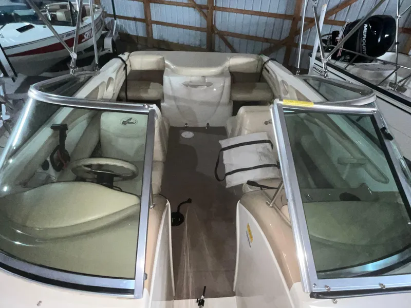 Slide: The Image of 2000 Sea Ray 185 Bow Rider boat interior with beige seating and steering wheel. - 12
