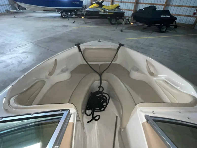Slide: The Image of 2000 Sea Ray 185 Bow Rider interior with seating and rope, stored indoors. - 13