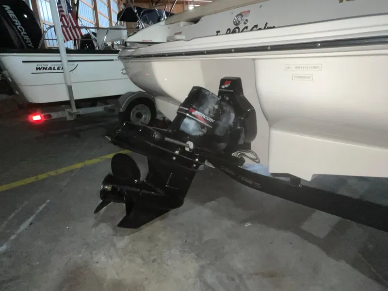 Slide: The Image of 2000 Sea Ray 185 Bow Rider boat with visible outboard motor in a storage area. - 8