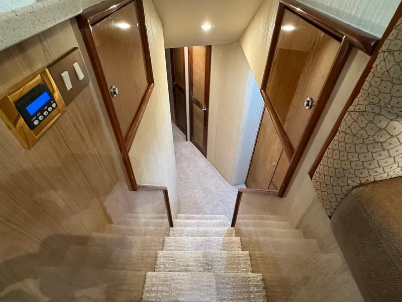 Slide: The Image of Staircase inside 2008 Ocean Yachts 54 Super Sport, featuring wooden doors and carpeted steps. - 22