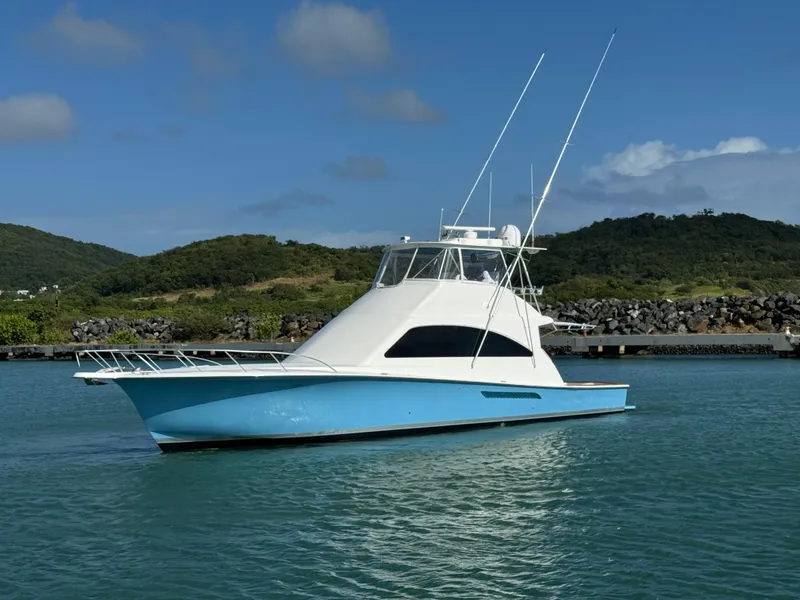 Slide: The Image of 2008 Ocean Yachts 54 Super Sport in serene waters, with lush green hills in the background. - 3