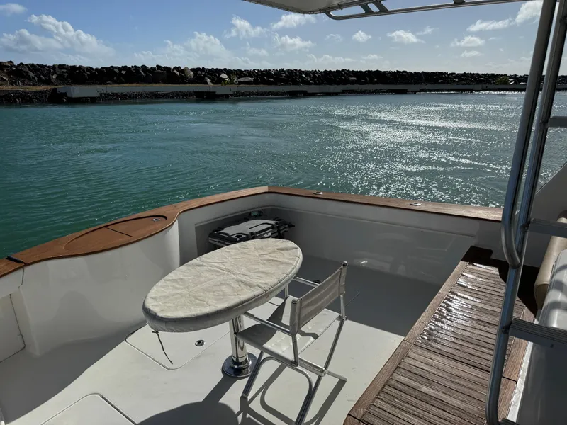 Slide: The Image of 2008 Ocean Yachts 54 Super Sport deck with table and chairs overlooking serene water. - 48