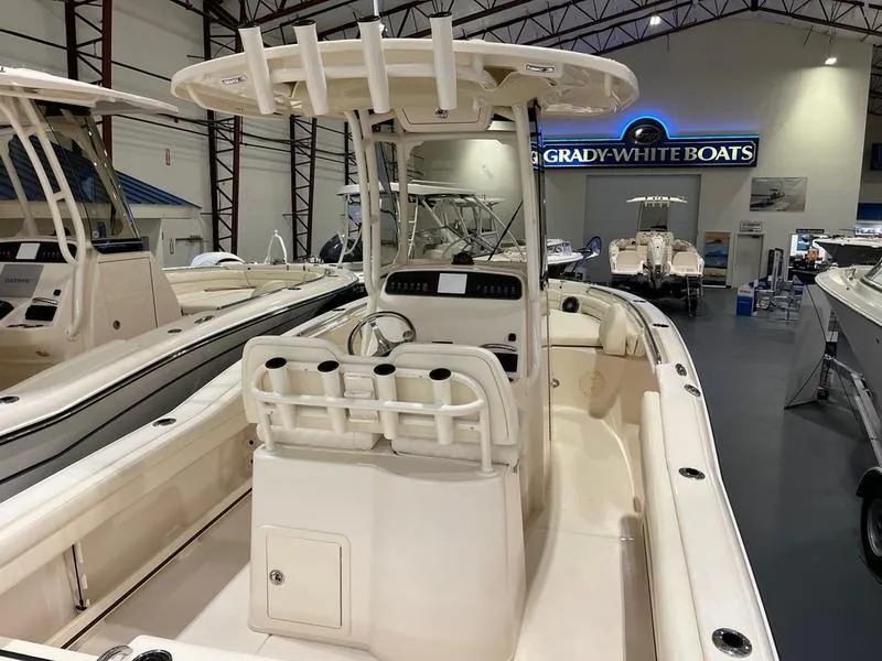 Slide: The Image of 2025 Grady-White Fisherman 216 boat displayed in showroom, featuring center console and seating. - 4
