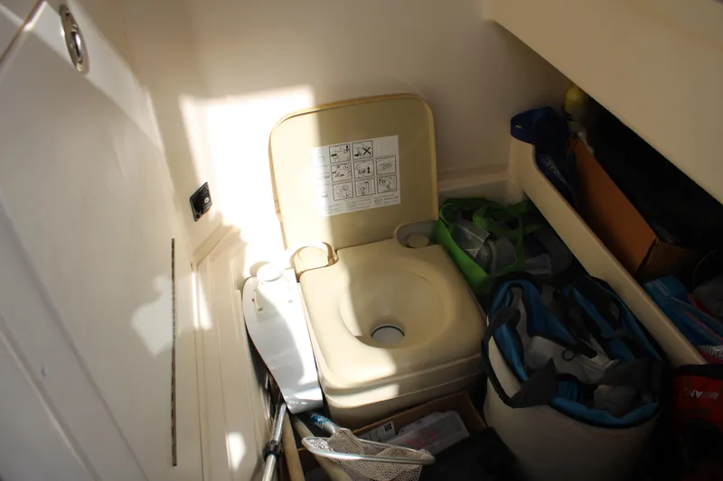 Slide: The Image of 2018 Grady-White Fisherman 257 boat interior with portable toilet and storage items. - 23