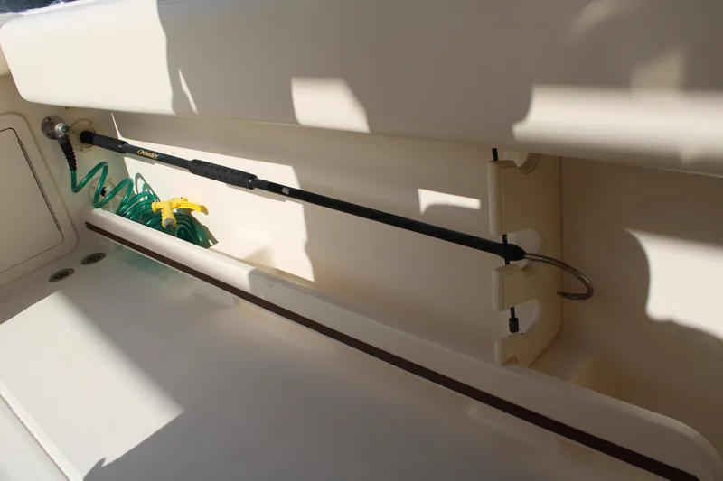 Slide: The Image of 2018 Grady-White Fisherman 257 boat interior with rod holder and coiled hose. - 47
