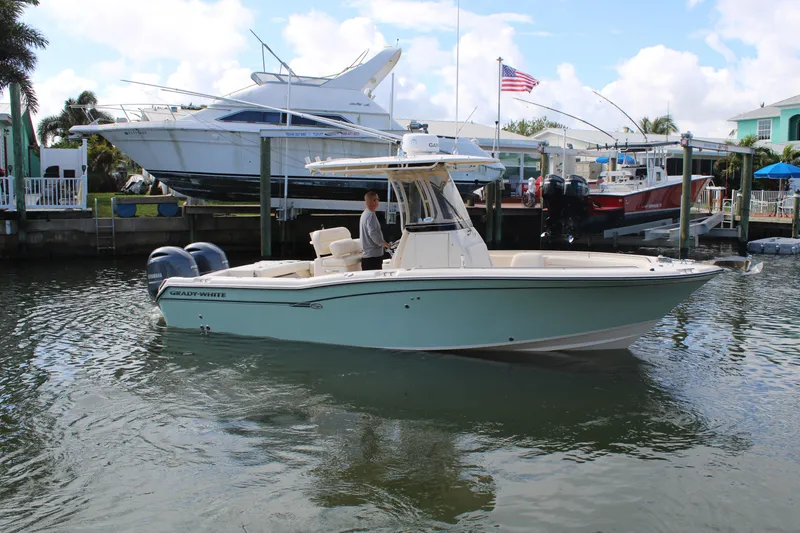 Slide: The Image of 2018 Grady-White Fisherman 257 boat docked in marina, clear sky, American flag visible. - 7