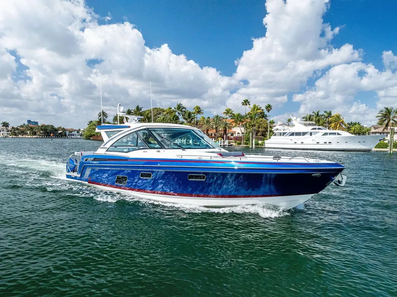 Slide: The Image of 2023 Formula 430 Super Sport Crossover cruising on a sunny day with palm trees in the background. - 2