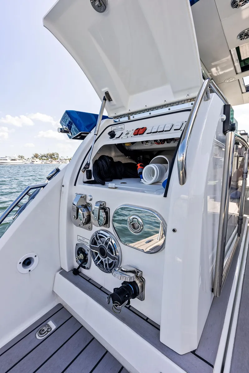 Slide: The Image of 2023 Formula 430 Super Sport Crossover boat with open storage compartment and control panel. - 28