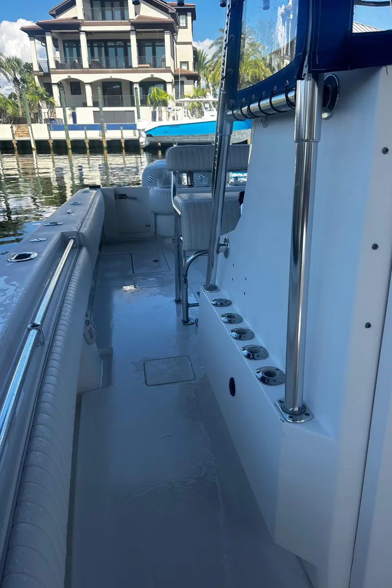 Slide: The Image of 2008 Contender 32 Tournament boat interior with rod holders, docked near waterfront property. - 16