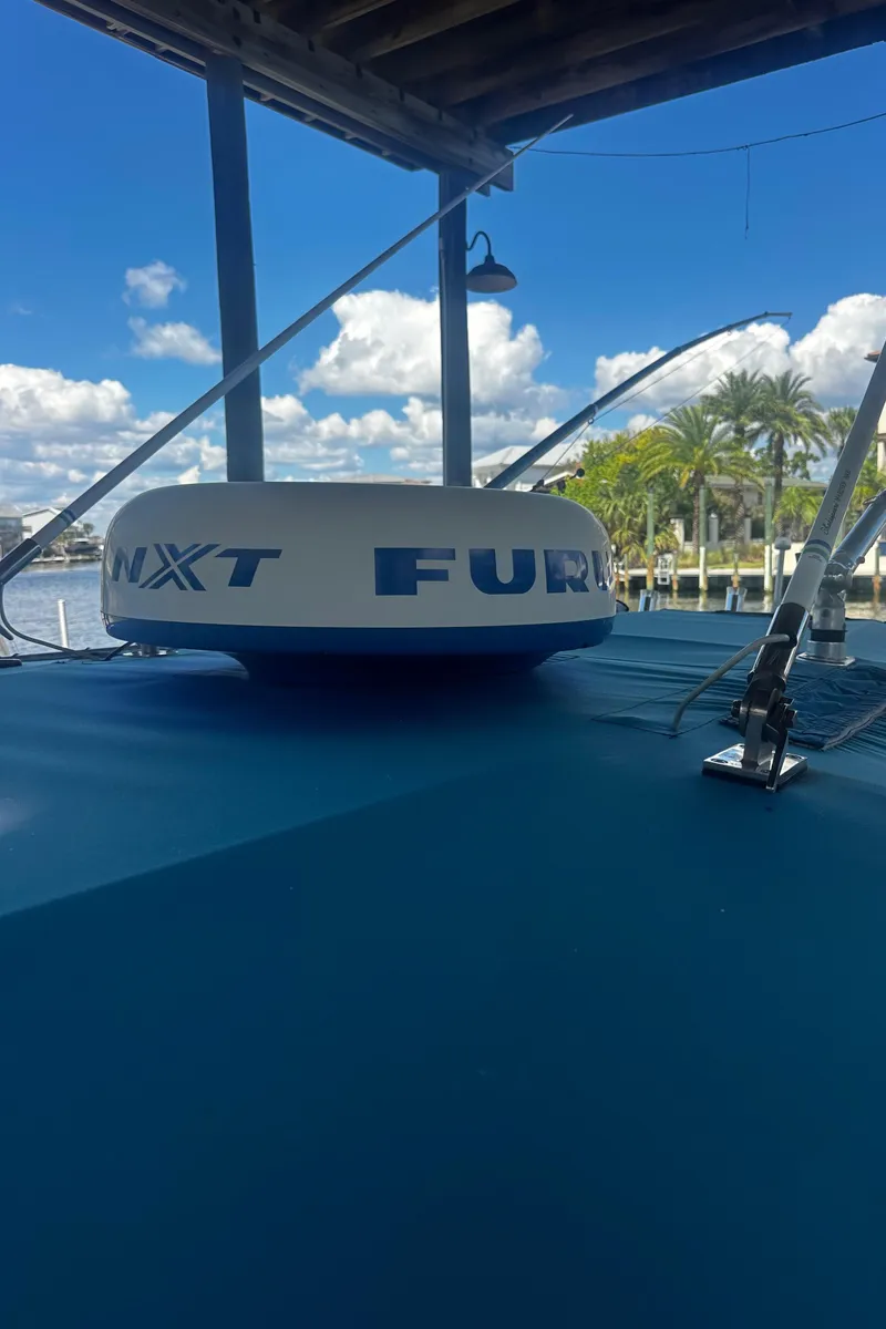Slide: The Image of 2008 Contender 32 Tournament boat with radar equipment, docked under a canopy. - 24