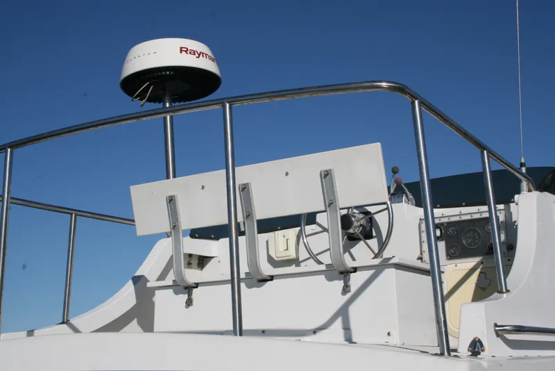 Slide: The Image of 1992 Sea Sport Sea Master 2700 boat helm with radar, stainless steel railings, and clear blue sky. - 16