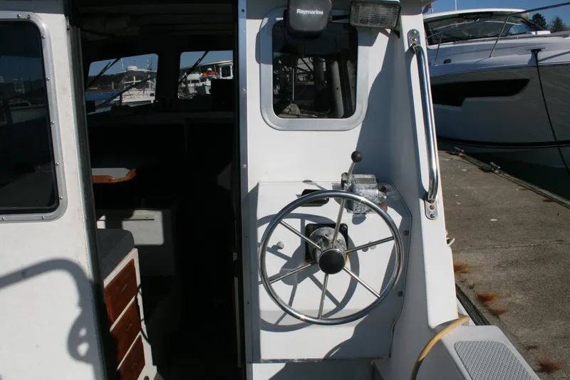 Slide: The Image of 1992 Sea Sport Sea Master 2700 boat helm with steering wheel and cabin entrance. - 2