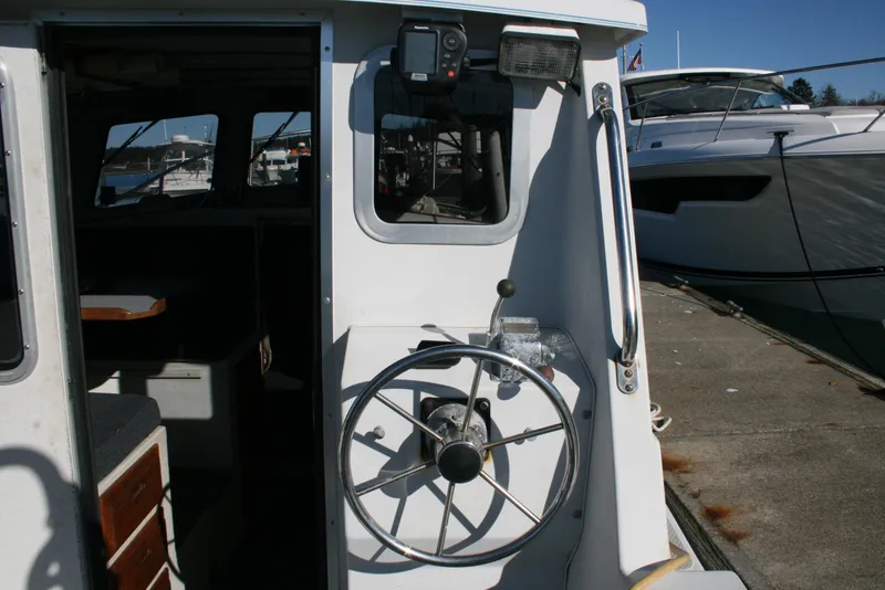 Slide: The Image of 1992 Sea Sport Sea Master 2700 boat helm with steering wheel, docked beside another vessel. - 3