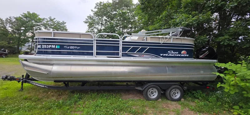 Slide: The Image of 2022 Sun Tracker PB 22 XP3 pontoon boat on trailer, parked outdoors near trees. - 4