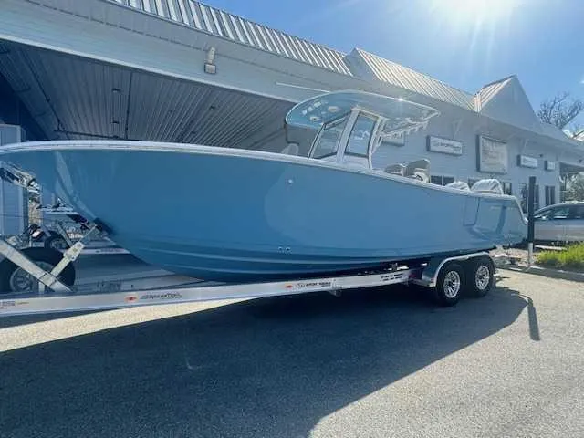 Slide: The Image of 2025 Sportsman Heritage 261 boat on trailer, parked outdoors under a sunny sky. - 34