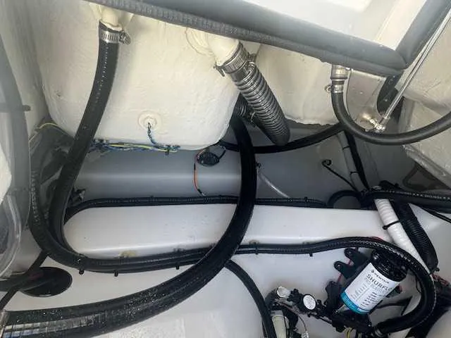 Slide: The Image of 2025 Sportsman Heritage 261 boat interior showing wiring and plumbing components. - 41