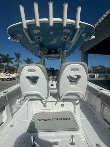 Slide: The Image of 2025 Sportsman Heritage 261 boat interior with seating and console, under clear blue sky. - 44