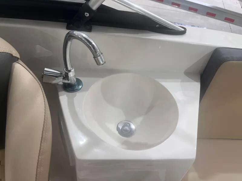 Slide: The Image of 2025 Ventura 195 Crossover boat sink with chrome faucet and beige seating. - 18