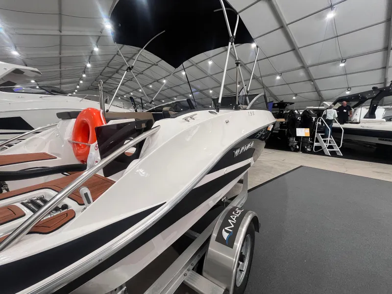 Slide: The Image of 2025 Ventura 195 Crossover boat displayed indoors, featuring sleek design and modern amenities. - 19