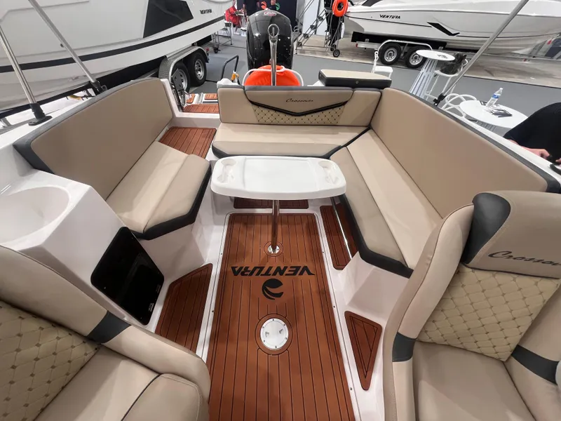 Slide: The Image of 2025 Ventura 195 Crossover boat interior with beige seating and wooden flooring. - 39