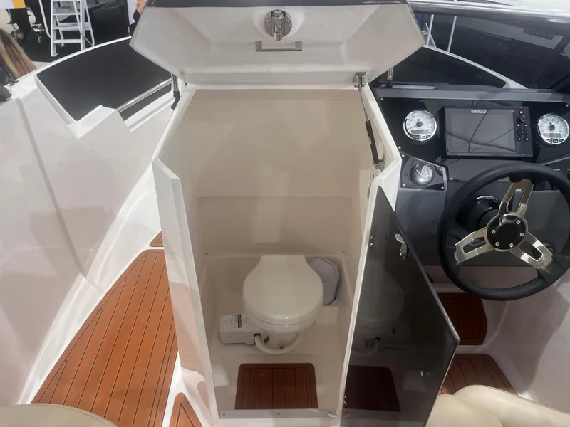 Slide: The Image of 2025 Ventura 195 Crossover boat interior with compact toilet and steering console. - 46