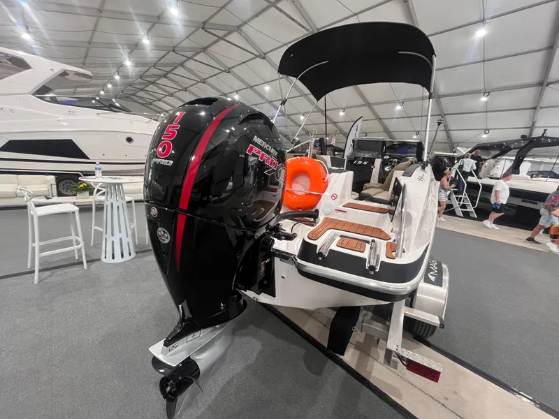 Slide: The Image of 2025 Ventura 195 Crossover boat with powerful outboard motor displayed at a boat show. - 6