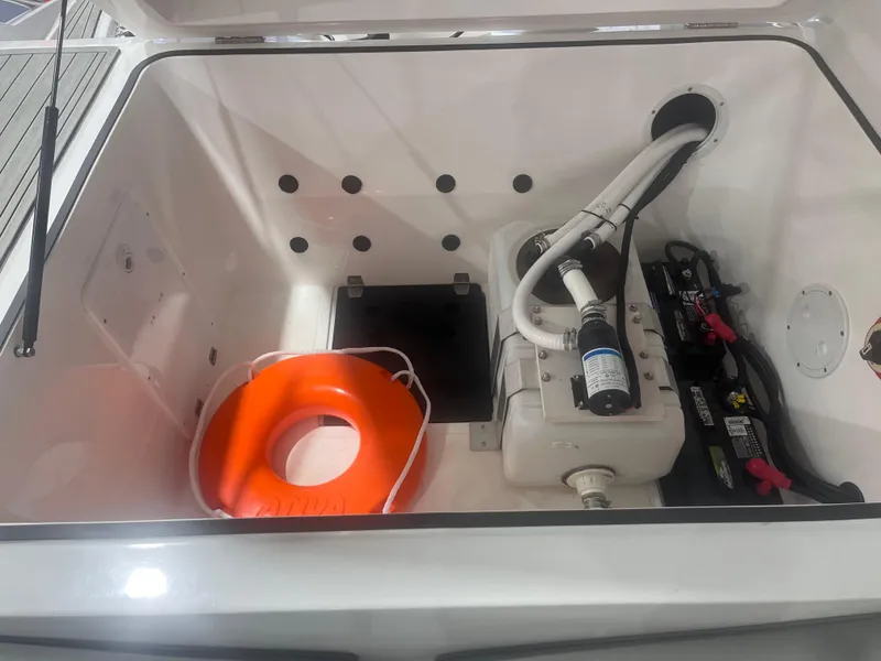 Slide: The Image of 2025 Ventura 252 Comfort boat storage compartment with life preserver and equipment. - 11