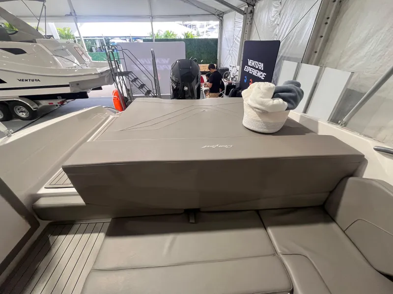 Slide: The Image of 2025 Ventura 252 Comfort boat interior with seating and storage, displayed at a boat show. - 14