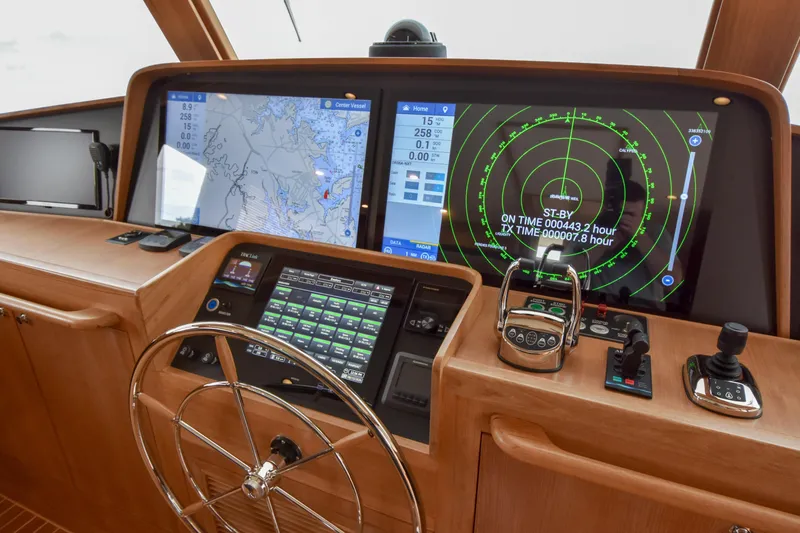 Slide: The Image of Control panel of a 2020 Fleming 78 yacht with navigation screens and steering wheel. - 31