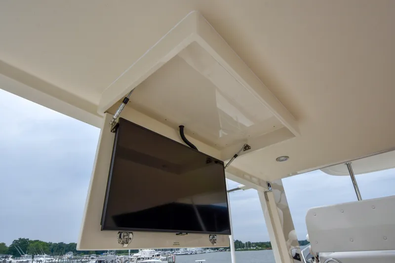 Slide: The Image of Ceiling-mounted TV on a 2020 Fleming 78 yacht, overlooking a marina. - 44