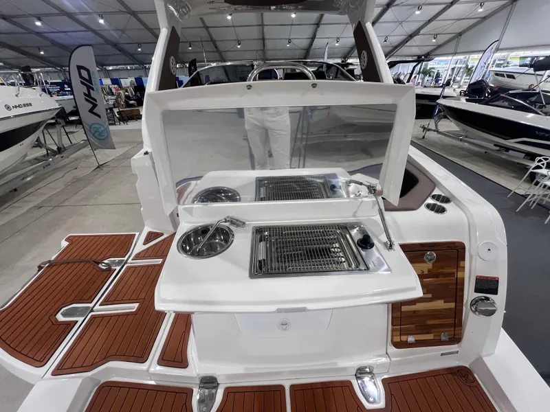 Slide: The Image of 2025 Ventura DayCruiser boat interior with modern kitchen setup and wooden deck. - 3