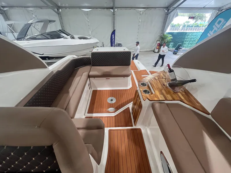 Slide: The Image of 2025 Ventura DayCruiser interior with luxurious seating and wooden accents in a showroom. - 6