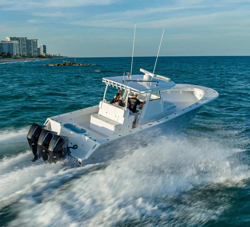 Slide: The Image of 2022 Onslow Bay 41 TE boat cruising on open water near a city skyline. - 1