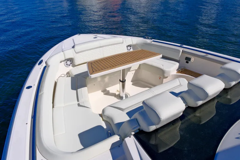 Slide: The Image of 2023 Tiara Yachts 48 LS boat interior with seating and table on calm water. - 15