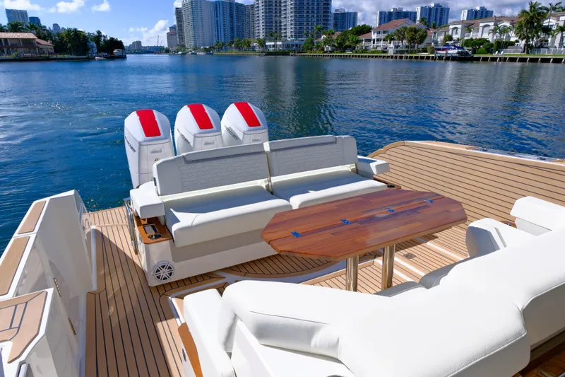 Slide: The Image of 2023 Tiara Yachts 48 LS luxury boat with spacious deck and seating, docked by waterfront. - 18