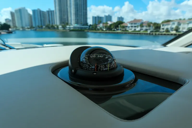Slide: The Image of Compass on 2023 Tiara Yachts 48 LS, with waterfront cityscape in background. - 36