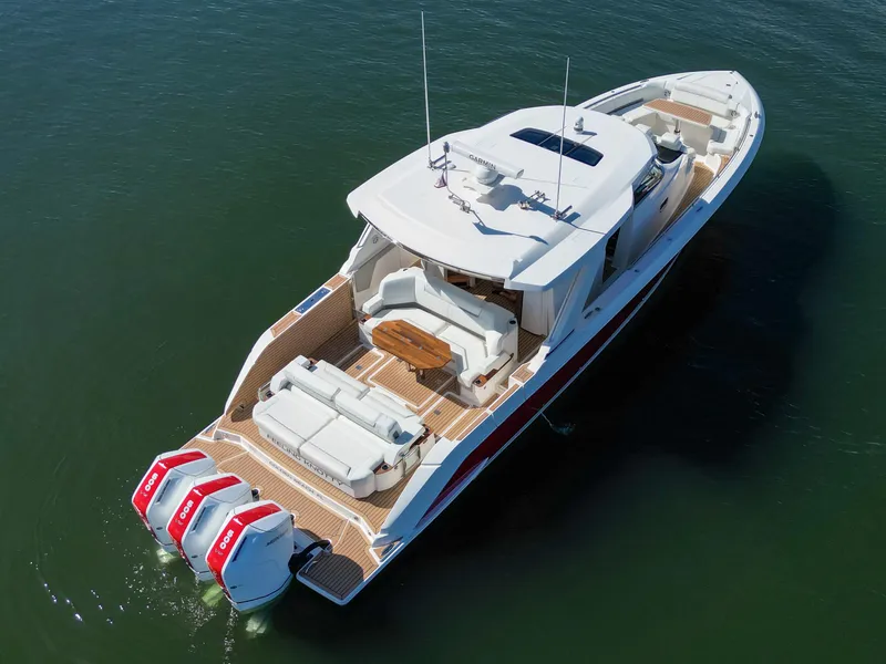 Slide: The Image of 2023 Tiara Yachts 48 LS luxury boat with triple outboard engines on calm water. - 8