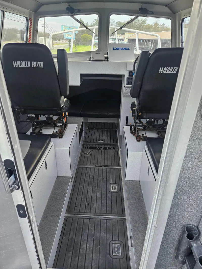 Slide: The Image of Interior of a 2020 North River 2500s boat, featuring seating and navigation equipment. - 11