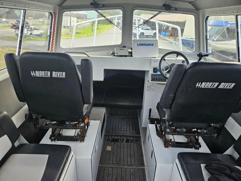 Slide: The Image of Interior of a 2020 North River 2500s boat with dual seats and steering wheel. - 12