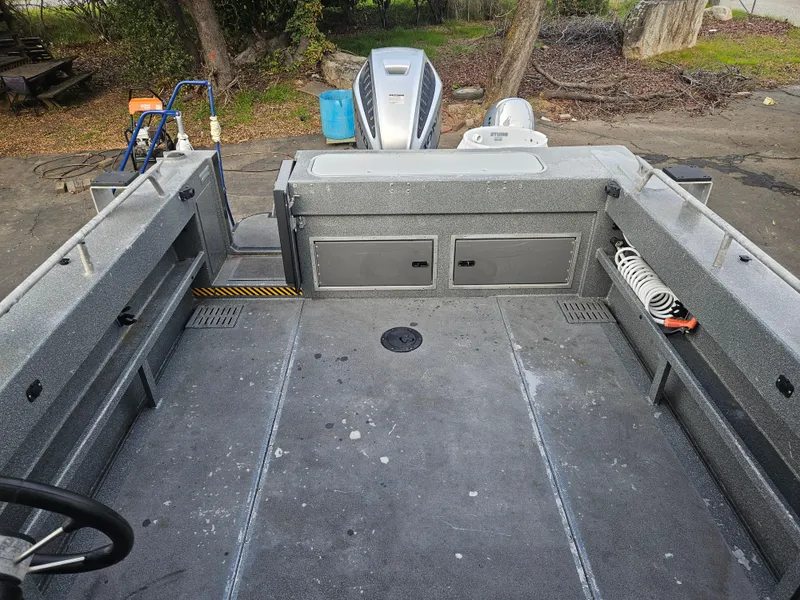 Slide: The Image of 2020 North River 2500s boat interior with storage compartments and outboard motor. - 16