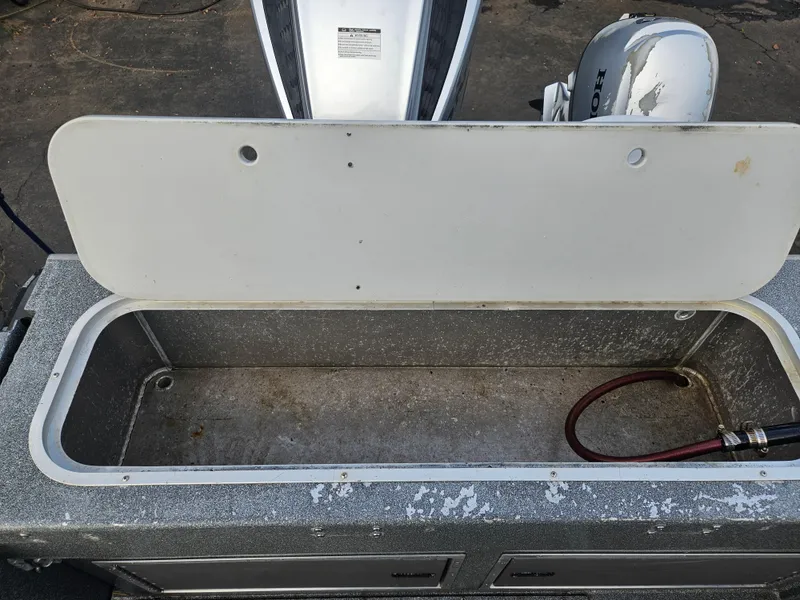 Slide: The Image of Open storage compartment on a 2020 North River 2500s boat with visible engine. - 21