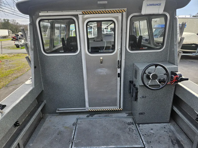 Slide: The Image of 2020 North River 2500s boat interior with steering wheel and cabin door. - 23