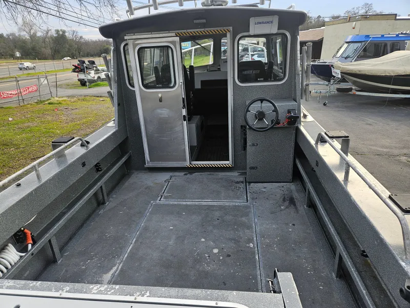 Slide: The Image of 2020 North River 2500s boat interior, featuring spacious deck and steering console. - 8