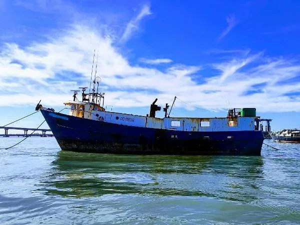 Slide: The Image of 1983 commercial freezer trawler on calm water under a clear blue sky. - 0