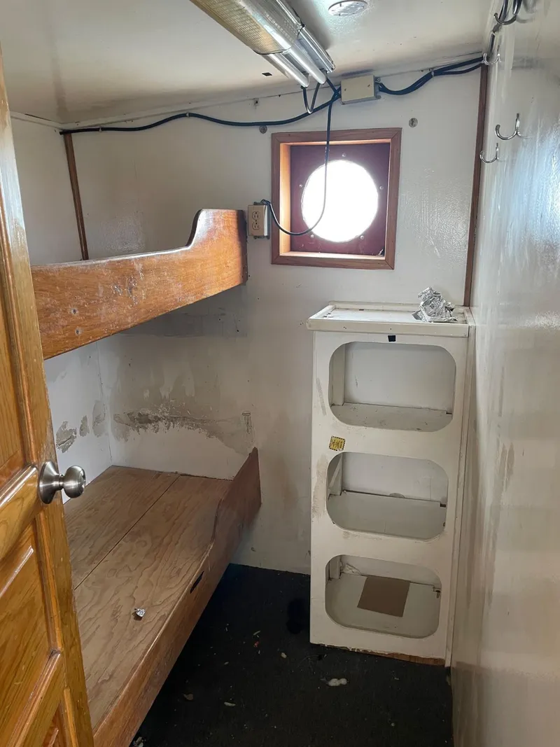 Slide: The Image of Interior of a 1983 commercial freezer trawler with boxes on a wooden counter. - 18