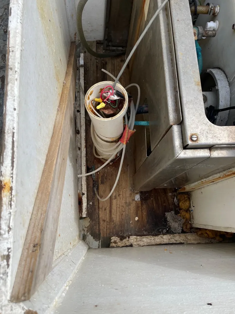 Slide: The Image of Rusty deck of 1983 commercial freezer trawler with winch, near calm water and trees. - 22
