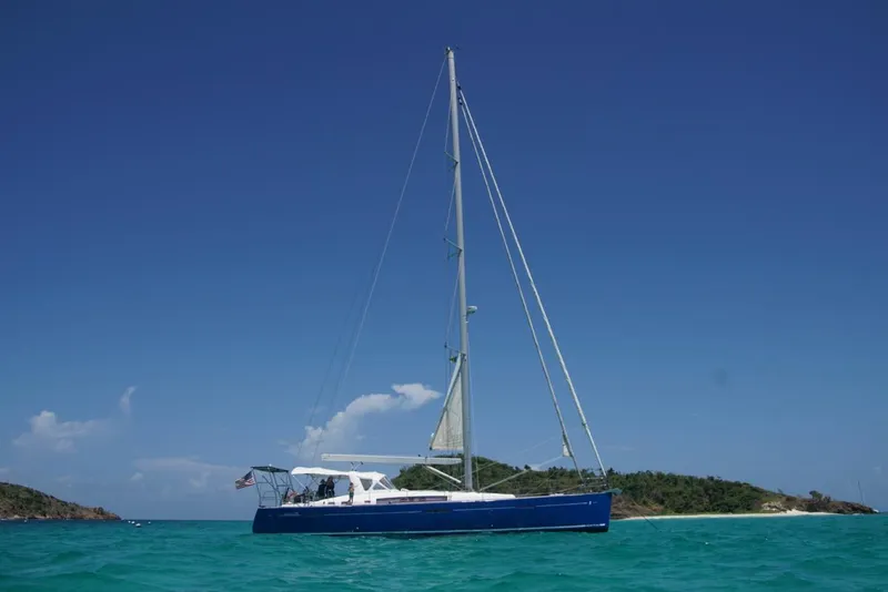 Slide: The Image of Beneteau Oceanis 58 sailboat, 2011 model, anchored in turquoise waters near a tropical island. - 1