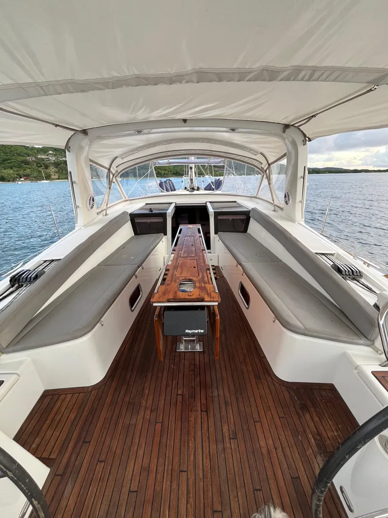 Slide: The Image of Spacious cockpit of 2011 Beneteau Oceanis 58 yacht with wooden flooring and cushioned seating. - 2
