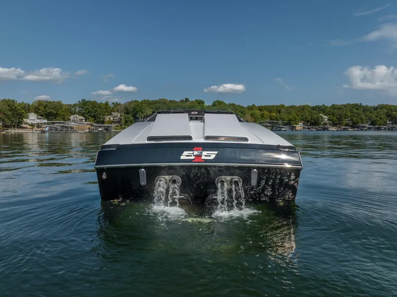 Slide: The Image of 2023 Cigarette 515 boat on calm lake, rear view, clear sky. - 10